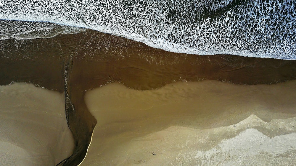 Drone view of the ocean washing on the sand beach shoreline at Arch Cape, Oregon, United States