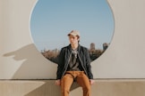 man sitting on gray concrete wall