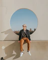 man sitting on gray concrete wall