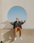 man sitting on gray concrete wall