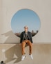 man sitting on gray concrete wall