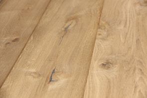 Uniform wooden planks with a natural grain and knots visible, displaying a smooth surface and light brown color. The texture and subtle variations in the wood give it a natural and rustic appearance.