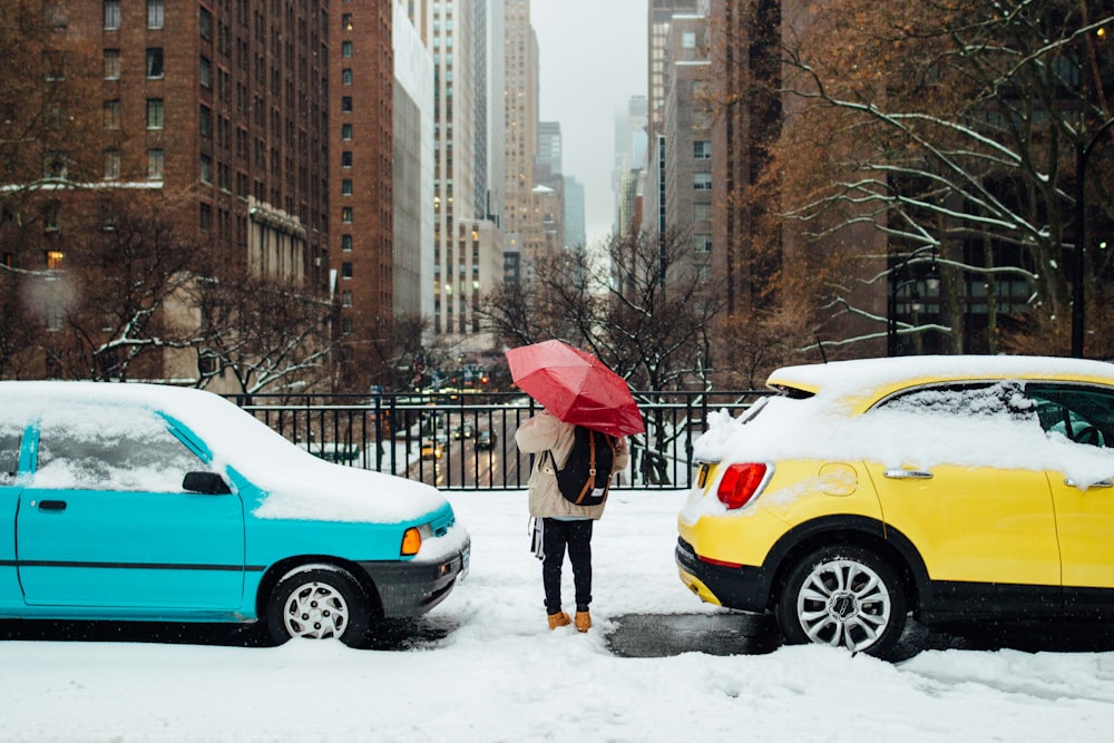 person standing in between two cars