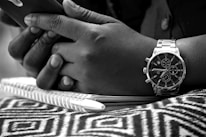 Close-up of hands holding a smartphone showing a shared timeline of photos and notes.