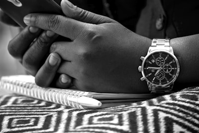 Close-up of hands holding a smartphone showing a shared timeline of photos and notes.