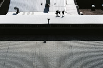 three men standing on gray pavement