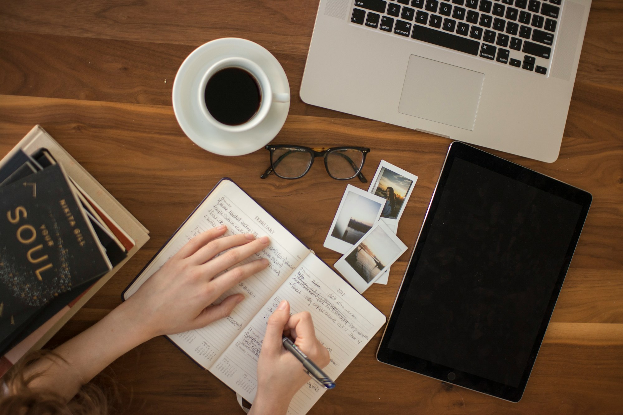 A person writing in a notepad with a pen