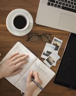 person holding ballpoint pen writing on notebook