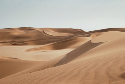 desert under clear blue sky during daytime desert teams background
