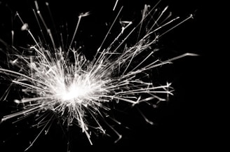 Sparks bursting outward in a dynamic and chaotic pattern against a dark background, creating a sense of movement and energy.