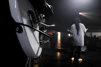 Close-up of Tom Pressley playing guitar under dim stage lights, eyes closed in deep emotion.