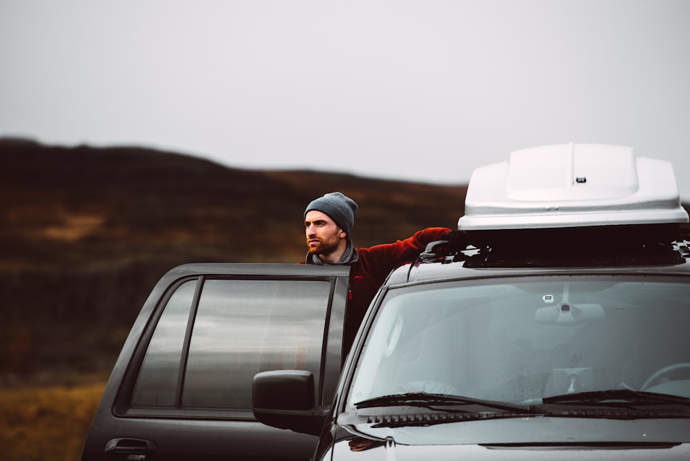 man standing beside of black SUV