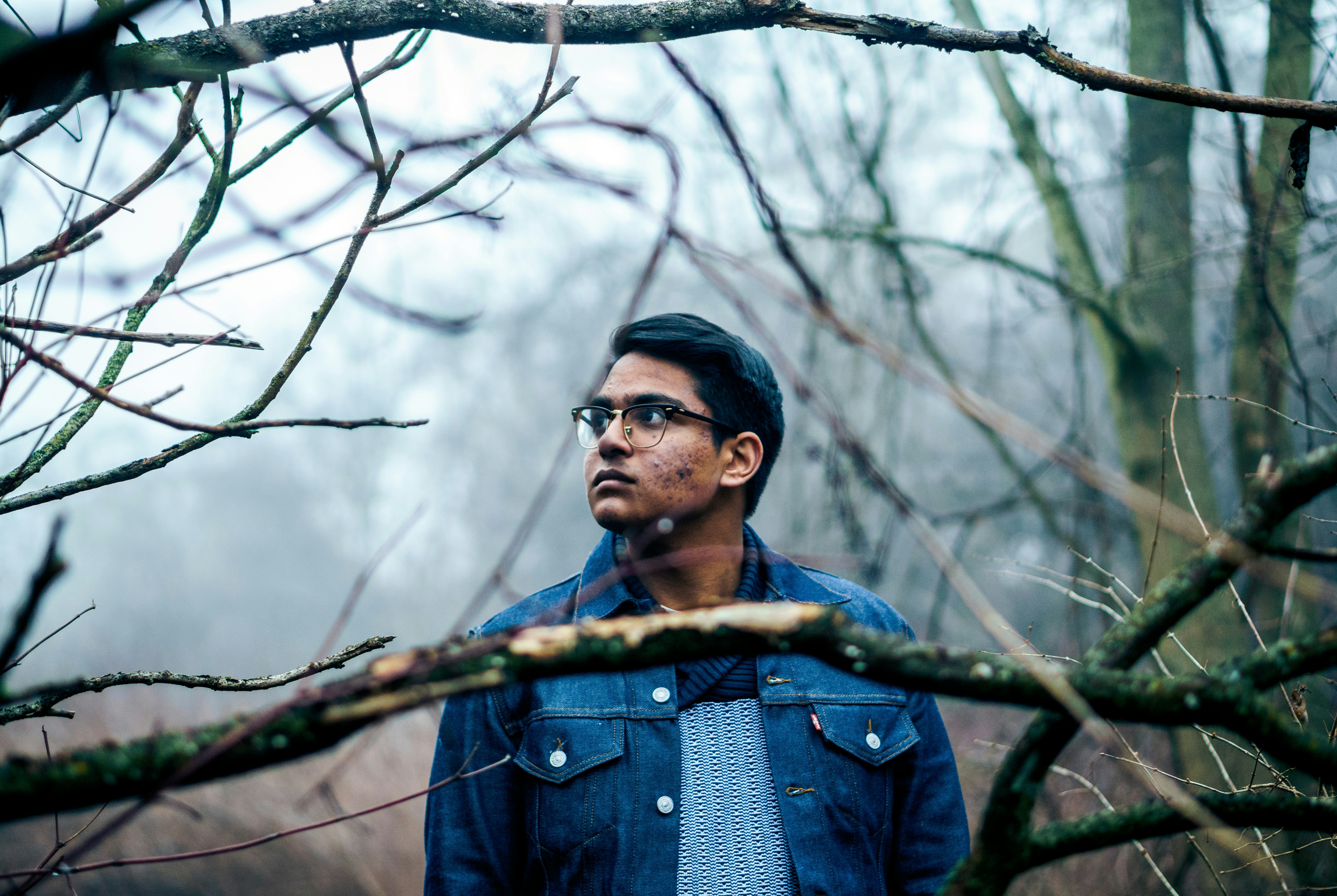 man standing near bare trees