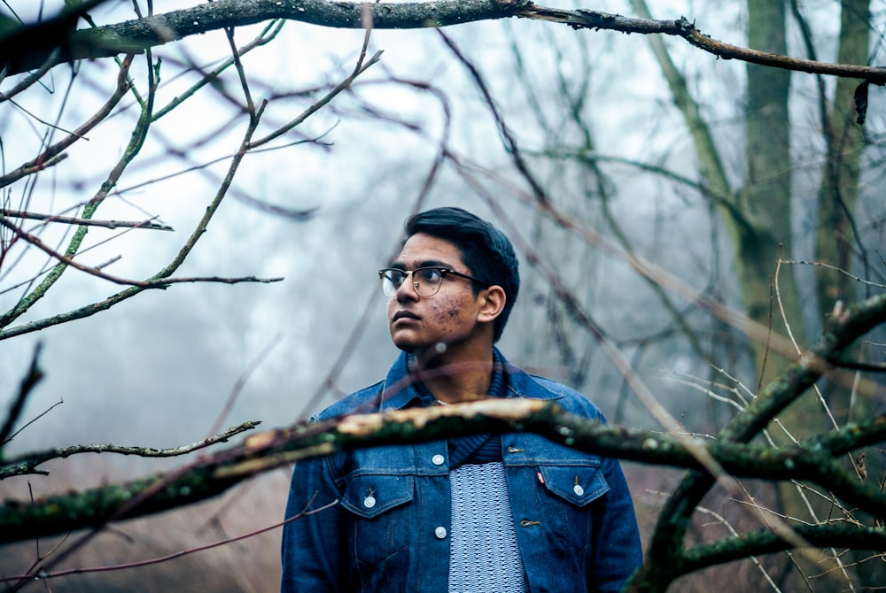 man standing near bare trees