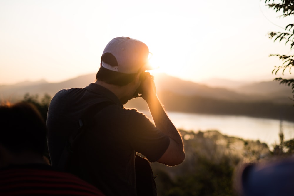 personne prenant une photo du coucher du soleil