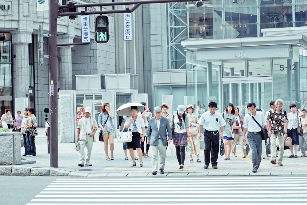 people crossing pedestrian lane near building at daytime