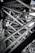 Intricate steel beams and trusses form a complex lattice structure, showcasing industrial design and engineering. The interlocking metal components create geometric patterns with rivets visible throughout the structure.