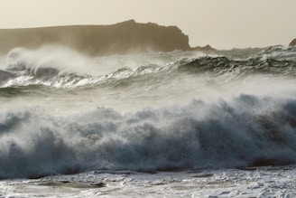 A powerful ocean storm with dark clouds and crashing waves along the Vancouver Island coastline.