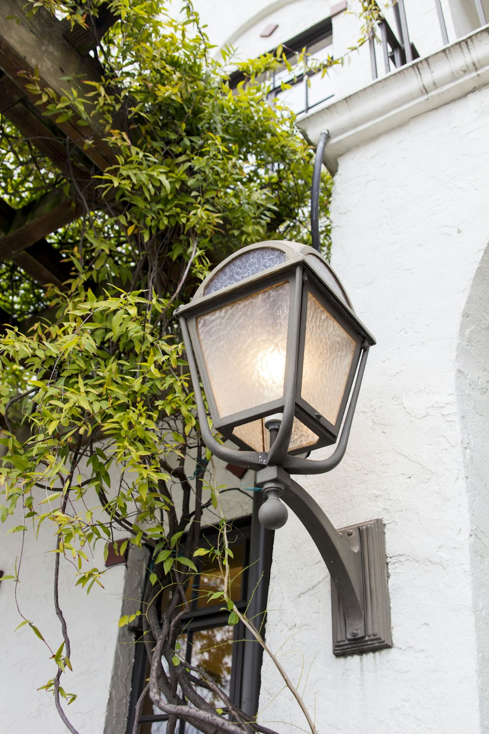 a lamp on the side of a white building