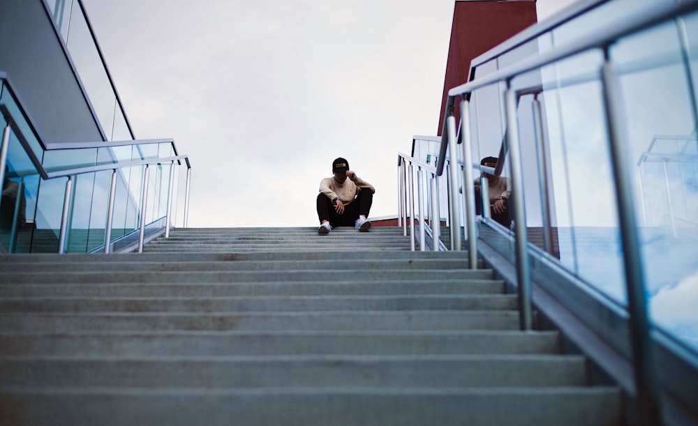 worm's eye view of man sitting on staircase