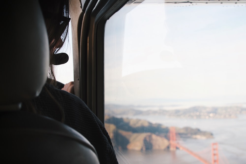 Frau fährt Fahrzeug und beobachtet die Golden Gate Bridge