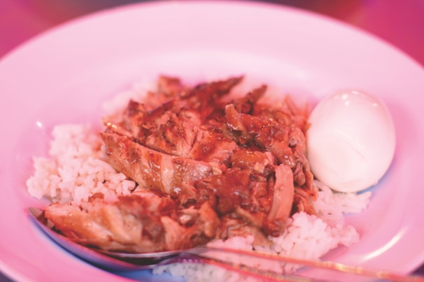 A vibrant plate of jerk chicken served with rice and peas.