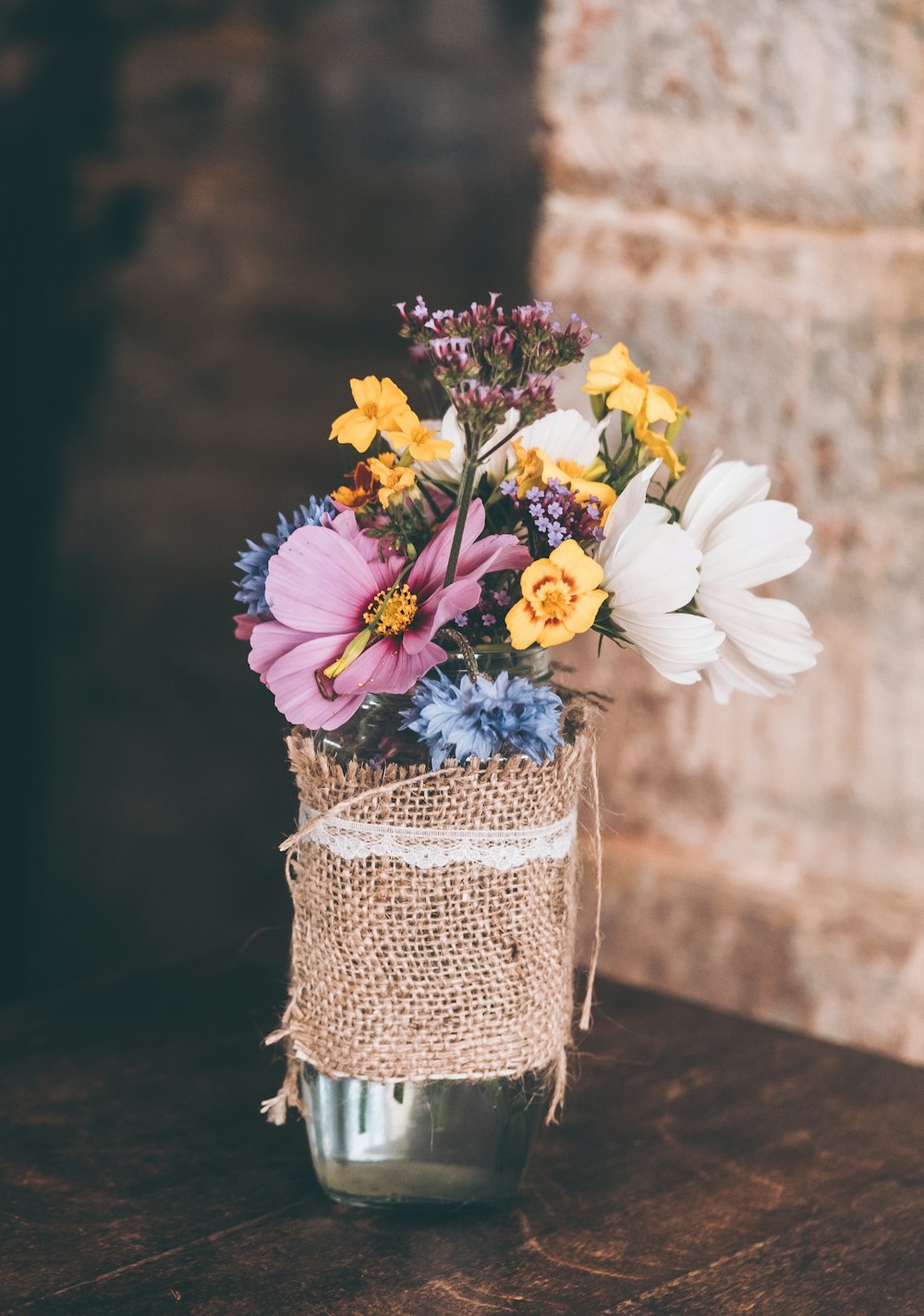 white and yellow petaled flowers in glass vase