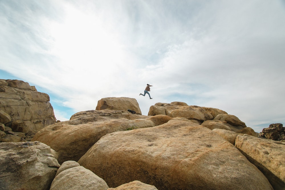 person jumping on rocks