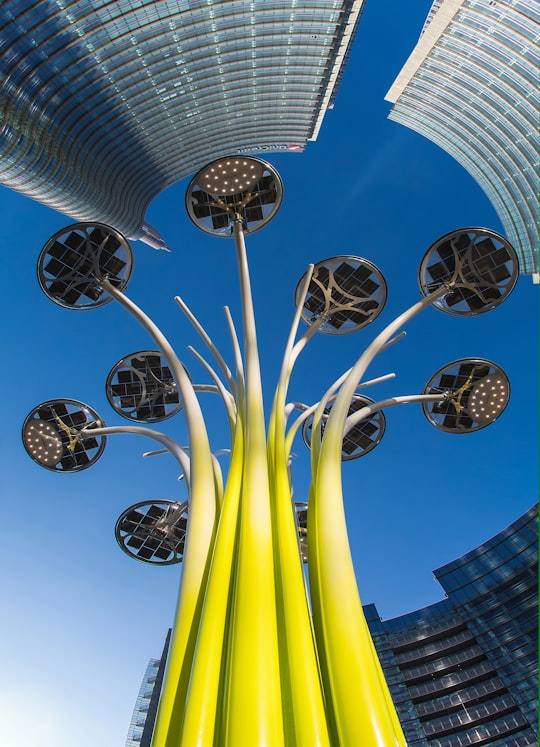 yellow and black tower low-angle photography in Piazza Gae Aulenti Italy