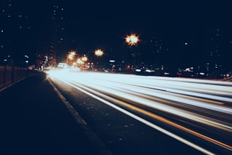 Long exposure shot of city lights creating streaks of color on a rainy night.