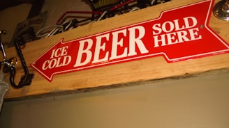 A crimson and black banner with the Wild Hunt Mead emblem hanging above a rustic shelf filled with mead bottles.