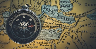 round gray framed compass on brown map