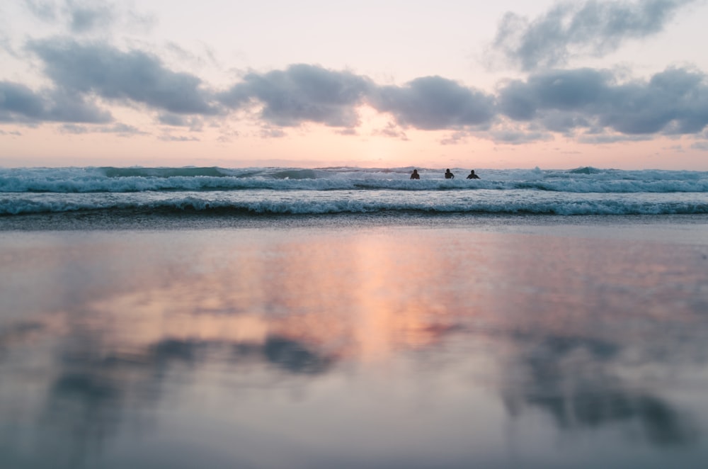 ocean under cloudy sky during sunset