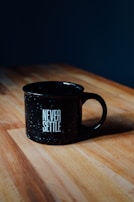 Close-up of a ceramic mug with a witty slogan printed, resting on a wooden table.