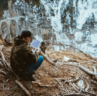 man holding white tablet computer outdoor