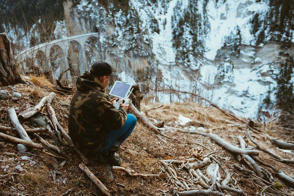 homme tenant blanc tablette ordinateur en plein air