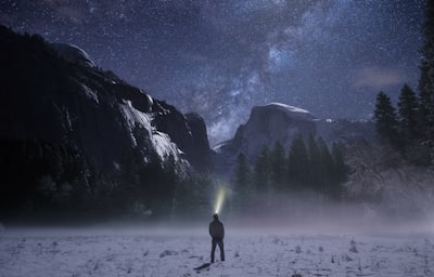 person wearing headlamp facing towards snow mountain wonder zoom background
