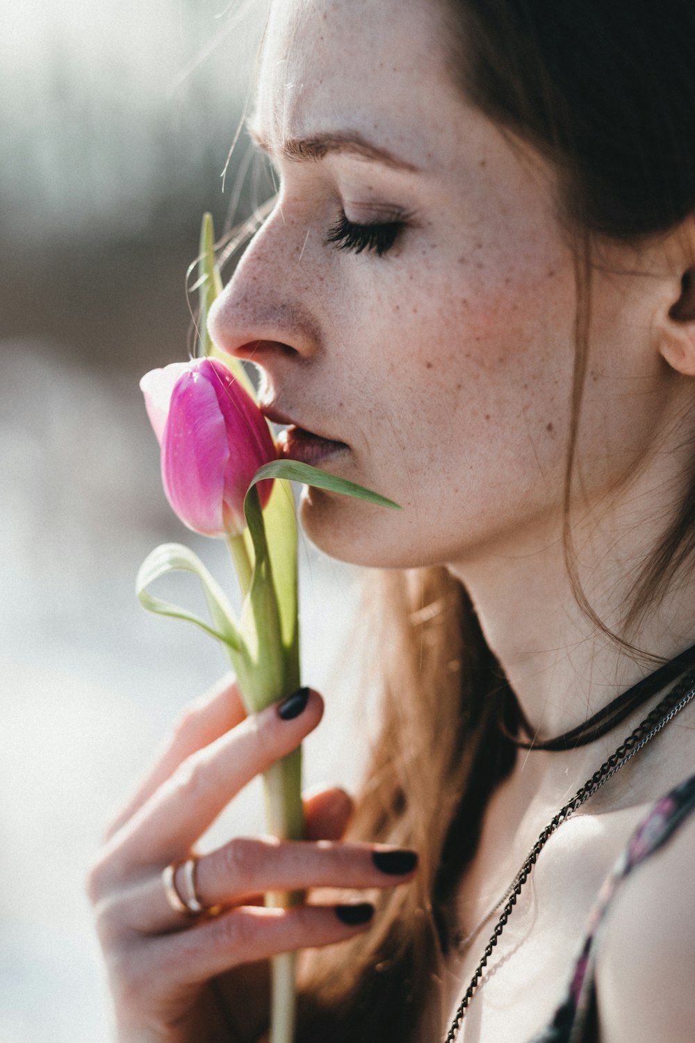 Frau mit rosa Rosenknospe