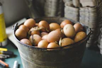 Neatly arranged small eggs in a wooden crate on a farm table