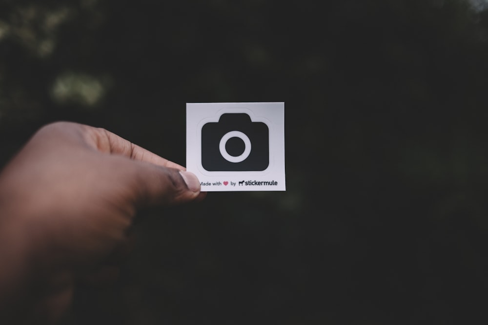 person holding white paper showing camera illustration