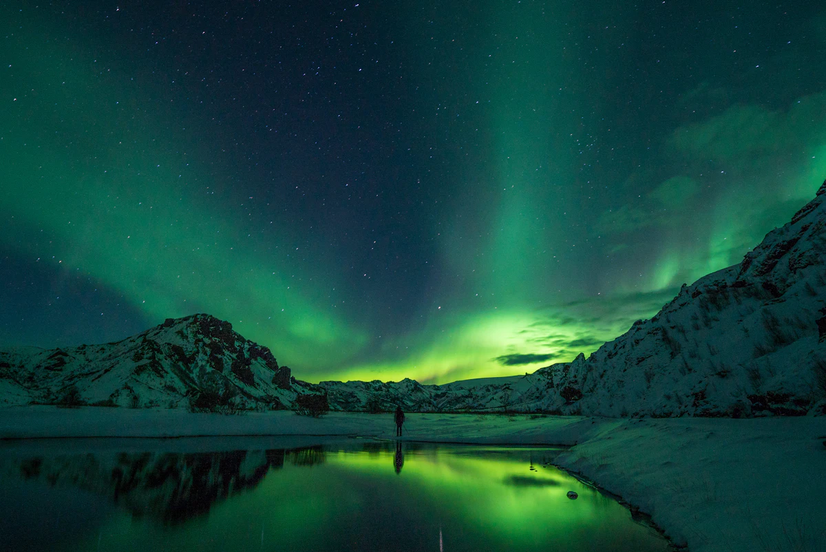 Aurora boreal verde reflejada sobre un lago en Thórsmörk, Islandia