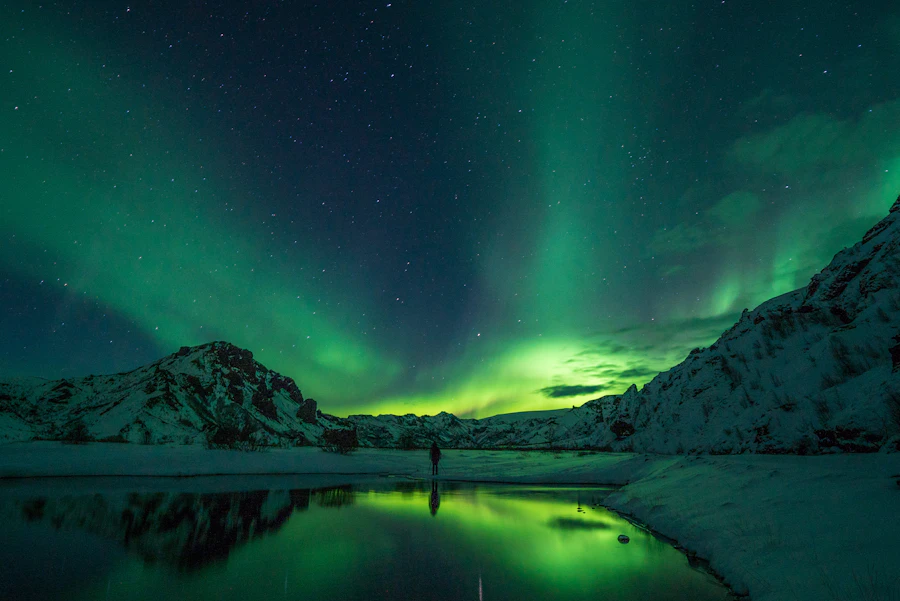 Aurora boreal sobre montañas nevadas en Islandia