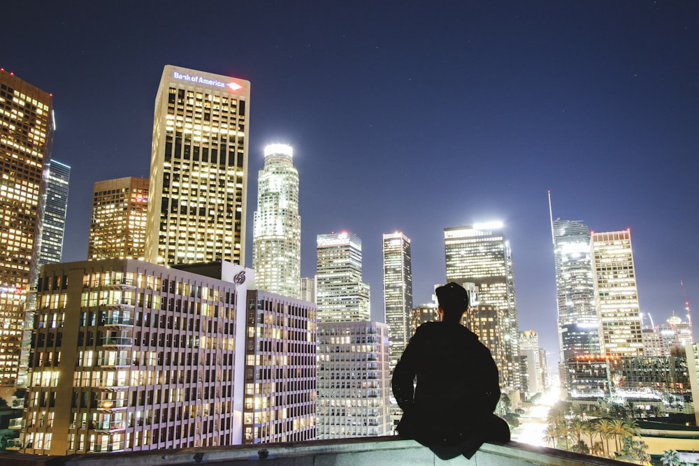 man sitting on rooftop during nighttime