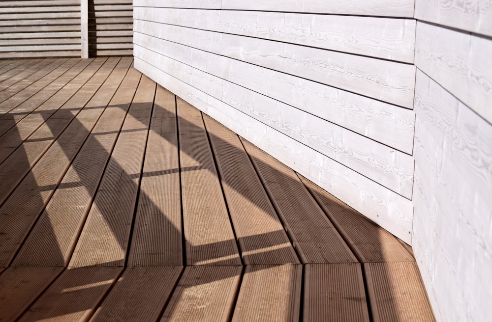 l’ombre d’une personne debout sur une terrasse en bois