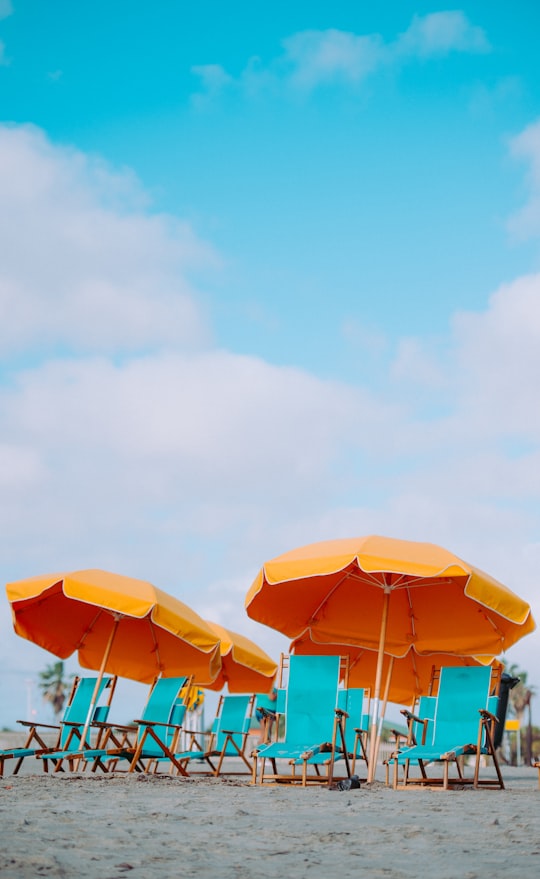 closeup photo of lounger chairs and beach umbrellas in Cocoa Beach United States
