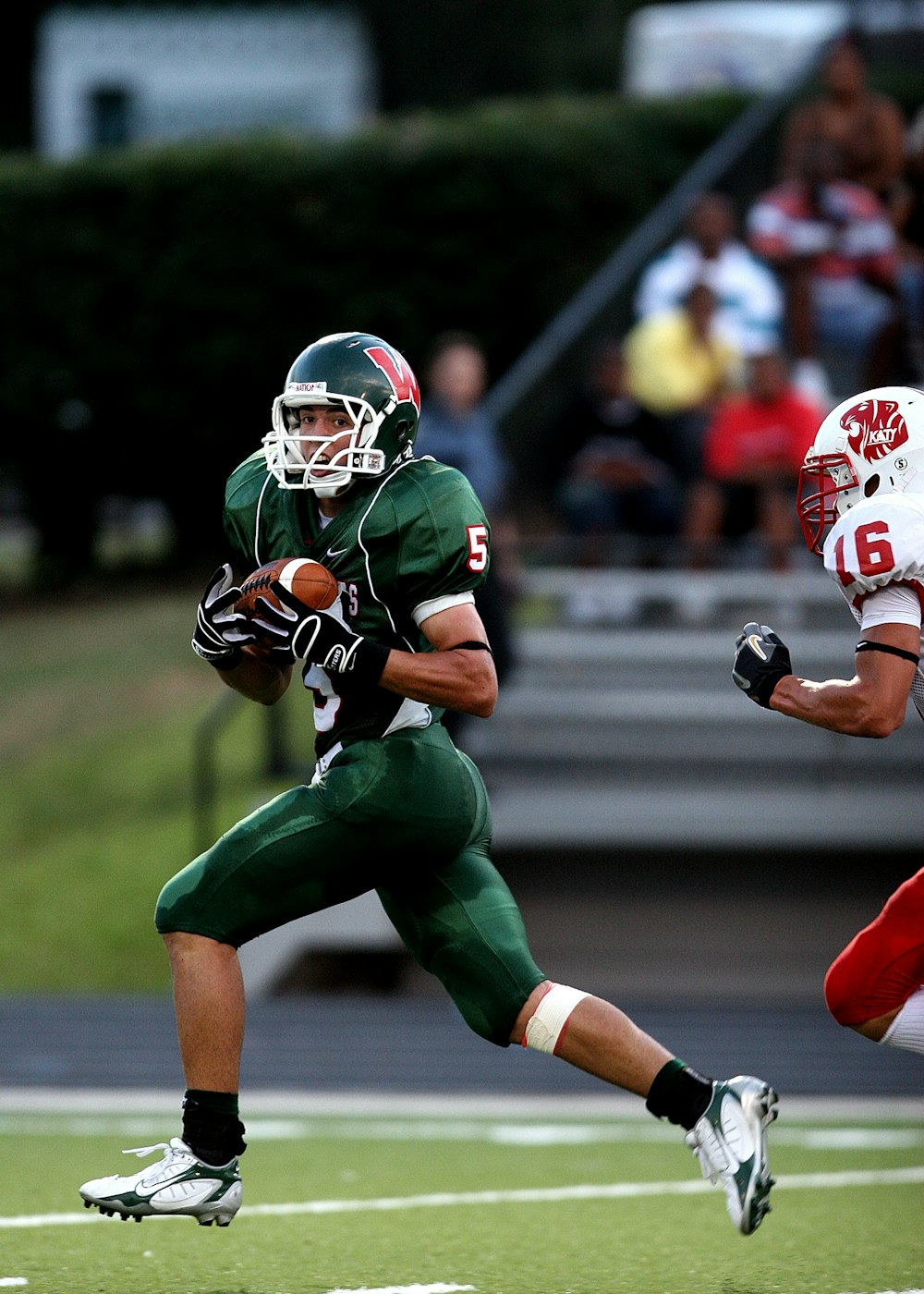 man in green 5 American football jersey holding ball