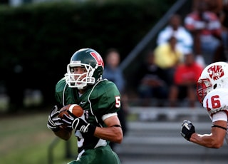 man in green 5 American football jersey holding ball