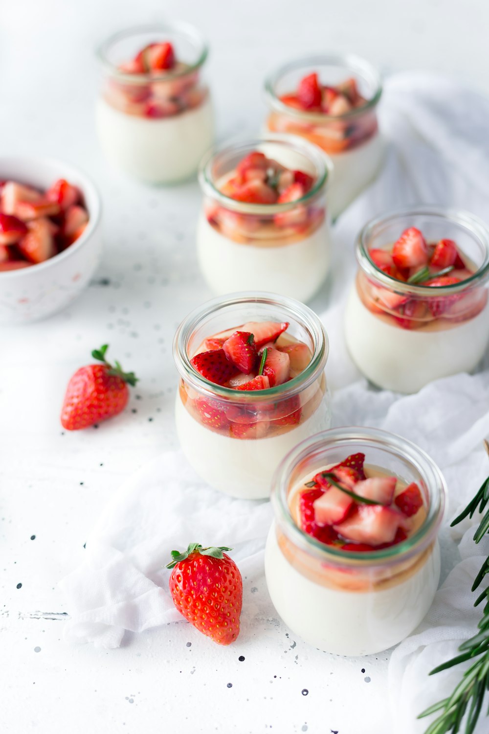 Geschnittene Erdbeeren im Klarglas mit Sahne