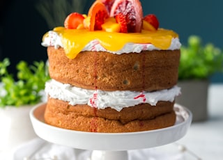 two-layered cake with citrus fruit and strawberry toppings