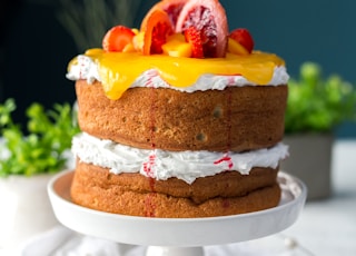 two-layered cake with citrus fruit and strawberry toppings